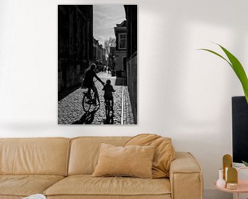 Moeder en kind fietsen onder de Dom by Gerard Til /  Dutchstreetphoto