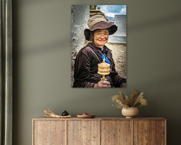 Tibetan woman with prayer wheel spinning by Rietje Bulthuis