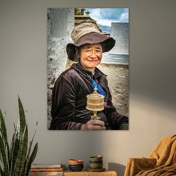 Tibetan woman with prayer wheel spinning