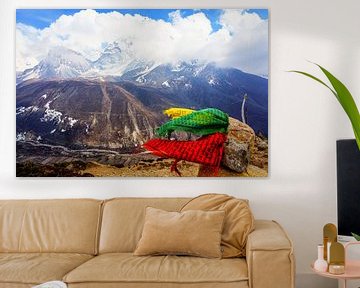 Des drapeaux de prières soufflent dans le vent, au sommet d'un pic himalayen.