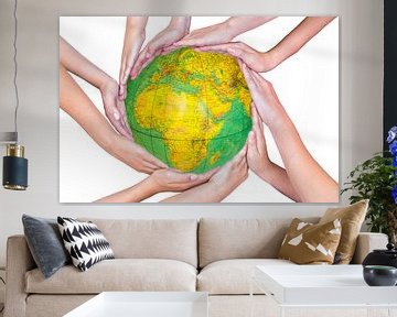 Arms of children with hands around globe sur Ben Schonewille