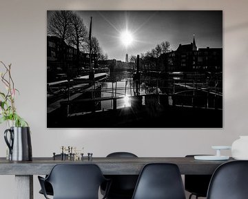 Tegenlicht in Utrecht: De zon, de Domtoren en de Zandbrug vanaf de Weerdsluis in Utrecht in zwartwit van De Utrechtse Grachten