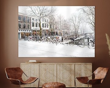 Winter in Utrecht. Besneeuwde fietsen op de brug over de Oudegracht. van De Utrechtse Grachten