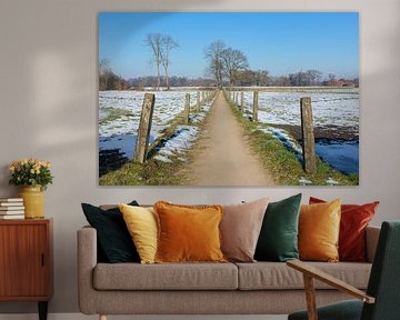 Sandpath between snowy meadows in dutch winter