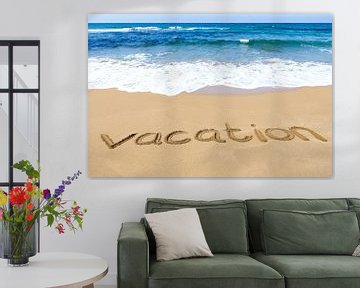 Woord 'vacation' geschreven in zand op strand aan zee
