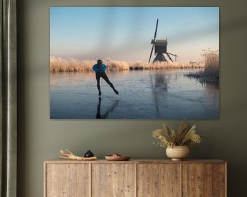 Eislaufen vorbei an frosted Schilf und eine Windmühle