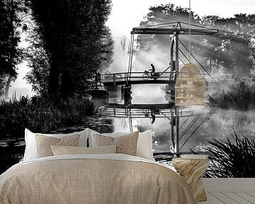 Eenzame krantenbezorger fietst over een brug in IJlst Friesland. One2expose Wout Kok Photography.  van Wout Kok