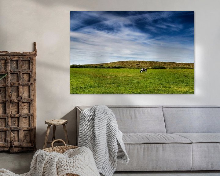 Sfeerimpressie: Wijds Terschellings landschap: blauwe hemel, groen gras en 1 koe van Paul Teixeira