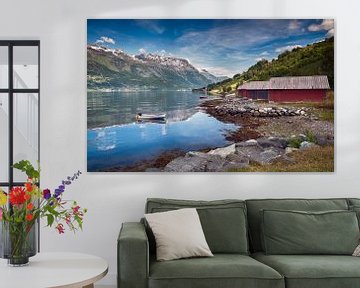 typisch rood huis aan een fjord in noorwegen met een bootje in het water