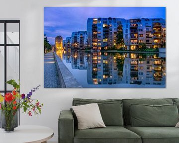 Apartments reflect in the water.