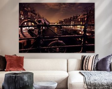 Fiets over een brug in Amsterdam Nederland bij nacht van Eye on You
