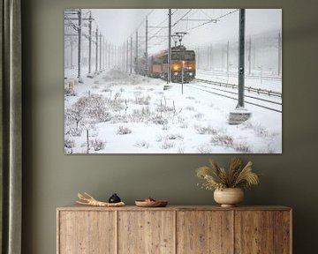 Rijdende trein in de sneeuw bij Amsterdam in Nederland van Eye on You