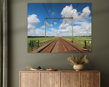 Traversée ferroviaire avec un chemin de fer infini à l'horizon avec un ciel bleu clair et des nuages