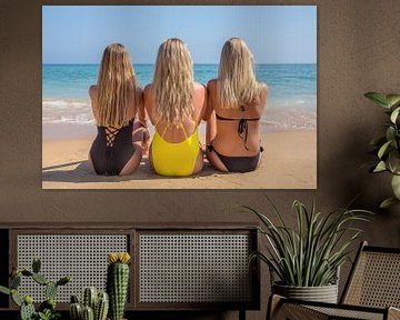 Drie blonde meisjes zitten op het strand van Ben Schonewille