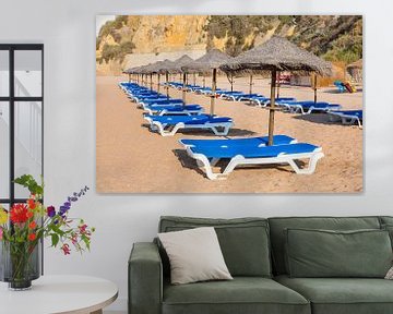 Rijen met strandparasols en blauwe ligbedden op strand in Albufeira Portugal van Ben Schonewille