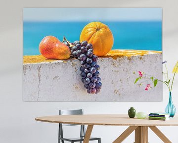 Fresh fruit lies on white wall in front of blue sea sur Ben Schonewille