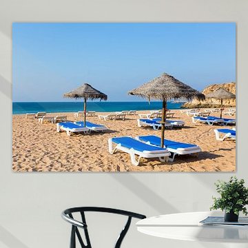 Gruppe Sonnenschirme und blaue Sonnenbetten auf Strand in Albufeira Portugal