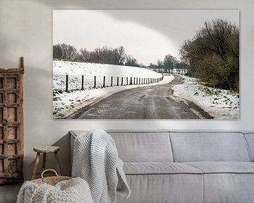 Landweg in een sneeuwlandschap van Ruud Morijn