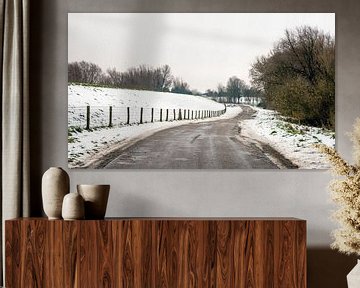 Landweg in een sneeuwlandschap van Ruud Morijn
