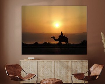 Jongen op kameel tijdens een zonsondergang in Jordanië van Nadine Geerinck