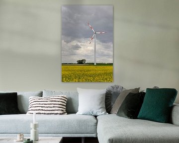 Wind turbine above a field of flowering yellow oilseed rape, renewable energy by wunderbare Erde