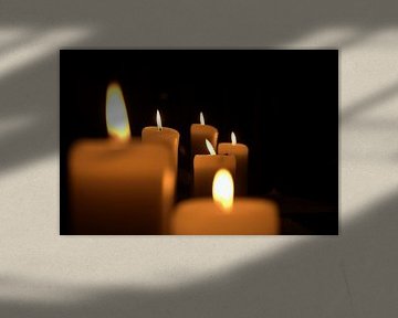 sechs brennende Kerzen in der Dunkelheit