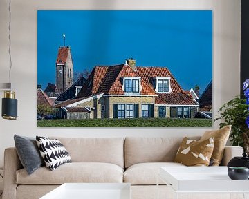Kerktoren en huizen van het Friese stadje  Makkum achter de IJsselmeerdijk.