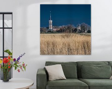 Het Friese dorpje Cornwerd met droog riet op de voorgrond. van Harrie Muis