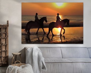 Horses on the evening beach at sea