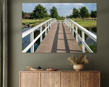 Witte kleine voetgangersbrug over gracht in woonwijk van Fotografiecor .nl