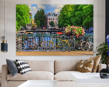 Fietsen op de brug in zomers Amsterdam van Dennis van de Water