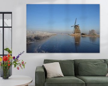 Winterlandschaft in den Niederlanden mit Windmühle und Eis