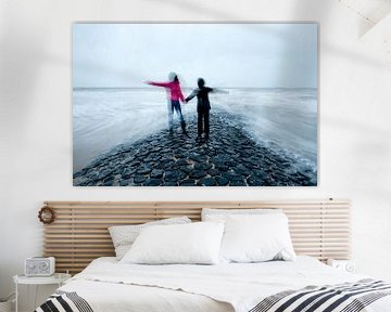 Zwei Kinder Hand in Hand auf Wellenbrecher im Meer von Remke Spijkers