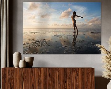 Künstlerischer Akt im Wattenmeer mit schönem Himmel, der sich im Wattenmeer spiegelt