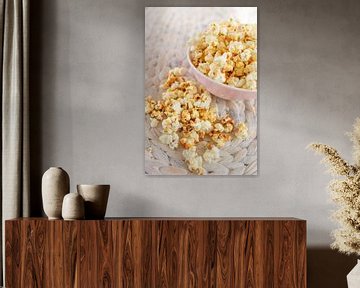 Fresh made popcorn lies in a cup on a table.