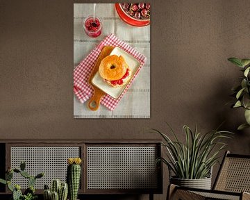 Een zelfgebakken bagel met roomkaas en kersenjam ligt op een bord van Edith Albuschat
