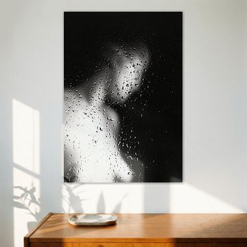 Naked young woman behind a window with raindrops.
