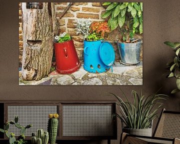 Colorful cans and buckets with flowers