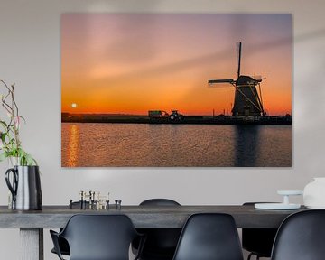 Typisches holländisches Bild mit Windmühle und Traktor während des Sonnenuntergangs von Wilco Bos