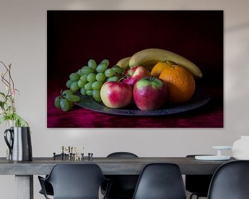 Stilleven van fruitschaal met vers fruit op warm rode achtergrond by Piertje Kruithof