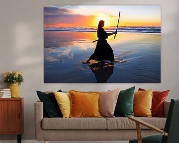 Samurai vrouw met Katana zwaard op het strand bij zonsondergang