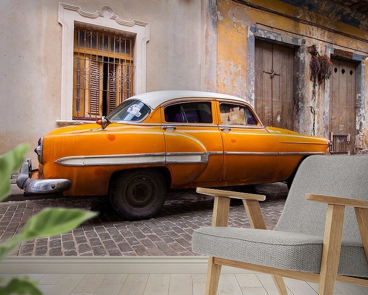 Sfeerimpressie behang: Oranje oldtimer in Cuba van Eveline Dekkers
