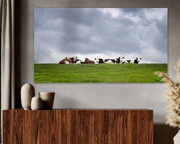 Koeien relaxen in het groene gras onder een bewolkte lucht van Michel Seelen