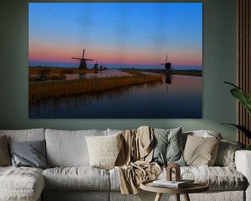 Windmolens langs de Kinderdijk met zonsondergang. van Brian Morgan