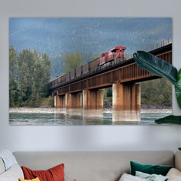 Cargo train crossing over a river bridge in beautiful Canada