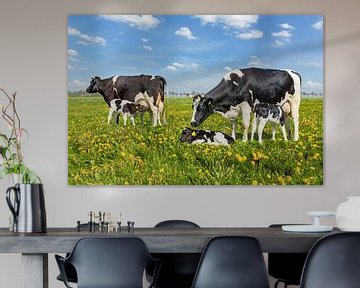 Twee koeien met drinkende kalfjes in Nederlandse weide met paardenbloemen van Ben Schonewille