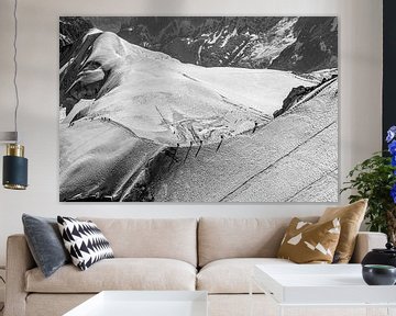 Bergbeklimmers op een bergrug in besneeuwd landschap (zwart-wit) van Martijn Joosse