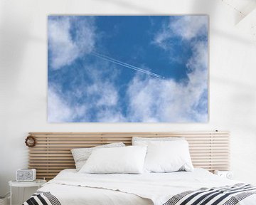 vliegtuig met condensspoor in de wolken van Frans Versteden