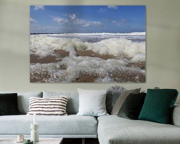 de blauwe zee met golven en veel schuim in de voorgrond in zeeland, holland in de winter in nederlan van Angelique Nijssen