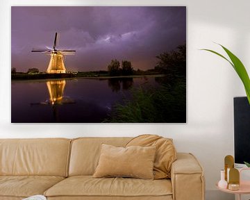 Illuminated windmill in Kinderdijk during heavy thunderstorms and storms by Jeroen Stel